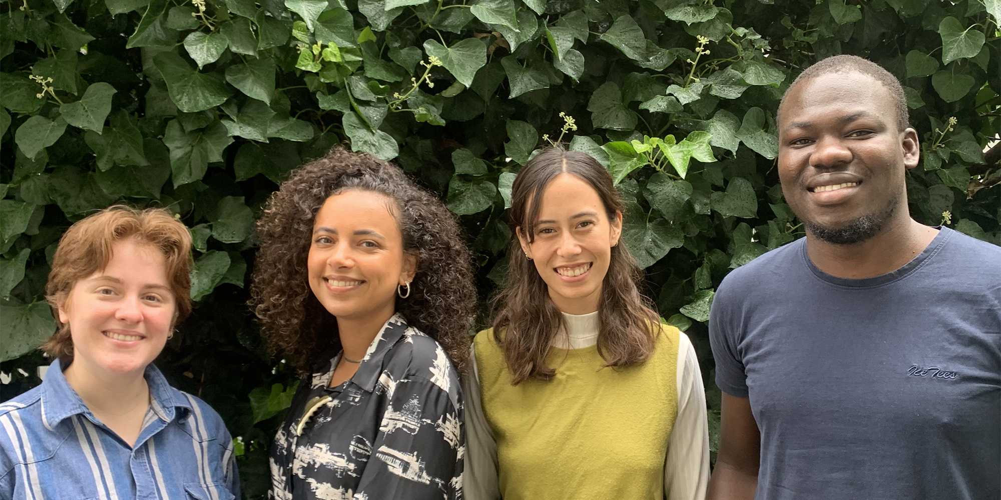 Francis, Salome, Vanessa, and Frank stand in front of a green bush