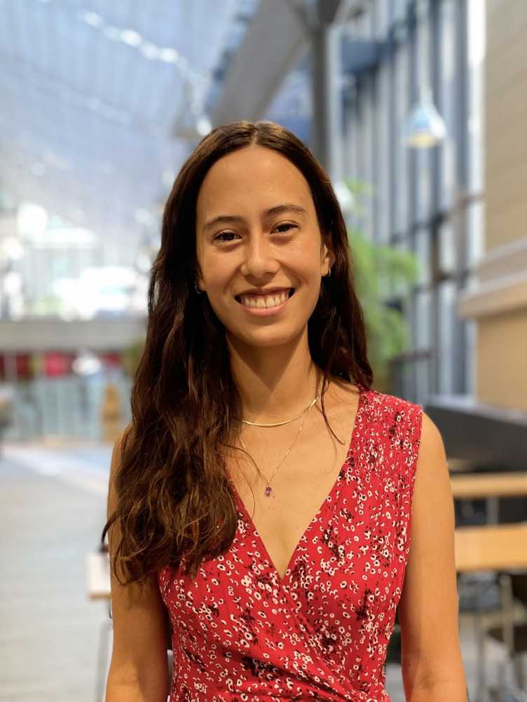 Vanessa stands in front of a blurred background at ETH and wears a pink dress