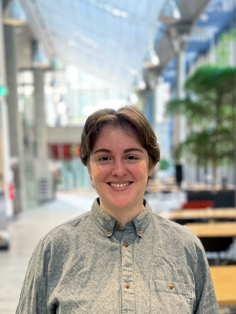 Francis stands in front of a blurred background at ETH and wears a grey shirt