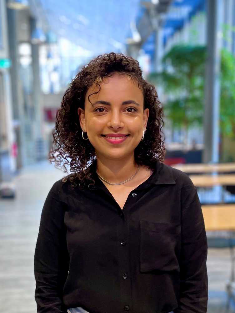 Salome stands in front of a blurred background at ETH and wears a black shirt