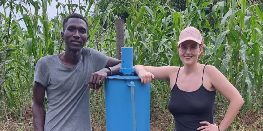 Aggrey and Julia stand with the second version of the pasteurizer