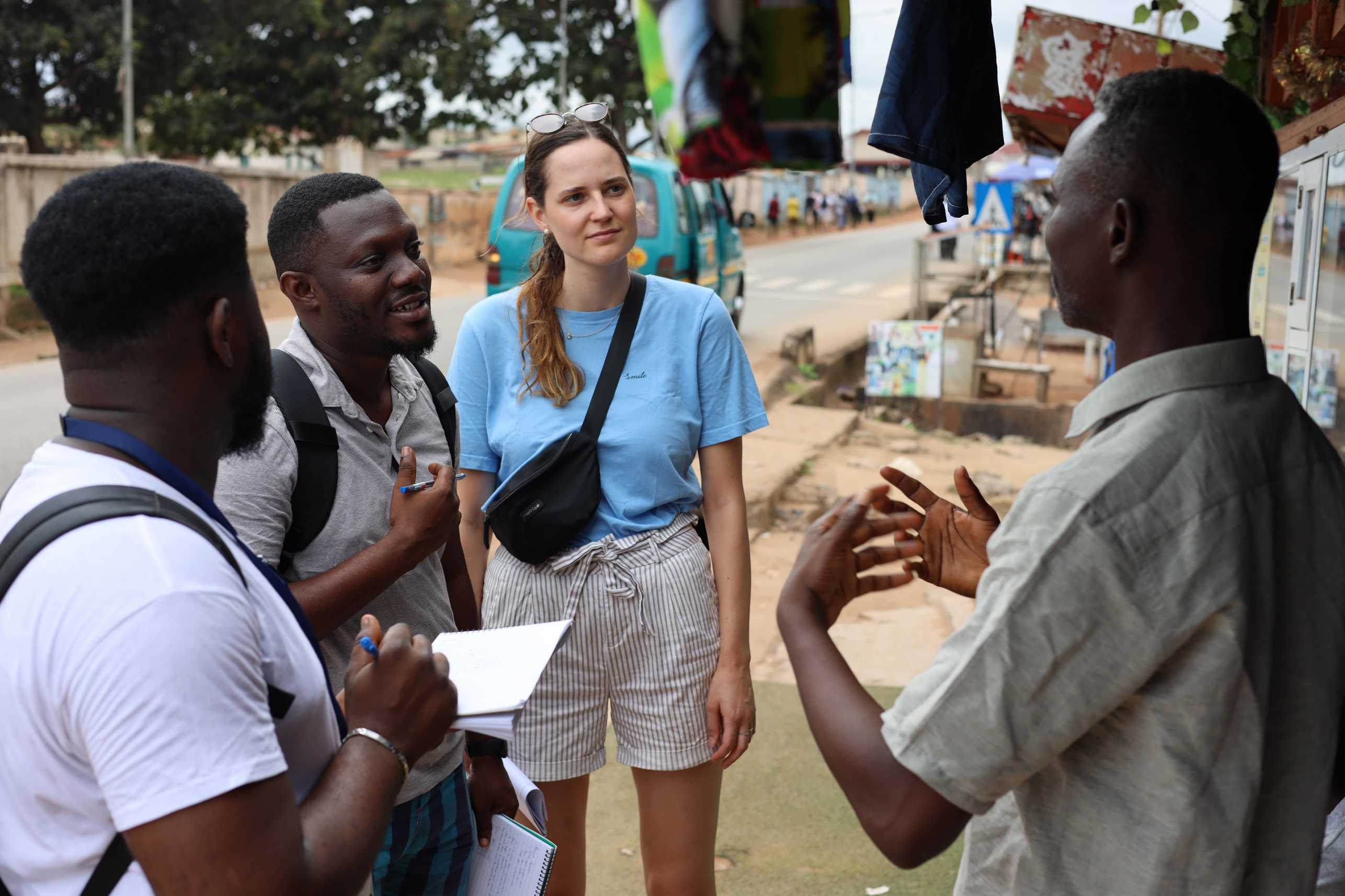 Students working on improving pedestrian walkways interviewing a shopkeeper in Kumasi.